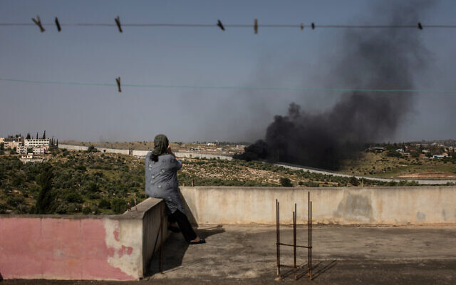 ميسون سويطي، فلسطينية تبلغ من العمر 54 عامًا من بيت عوا ، تجلس على سطح منزلها وتشاهد الدخان يتصاعد، 26 أبريل، 2019.(Tamir Kalifa)