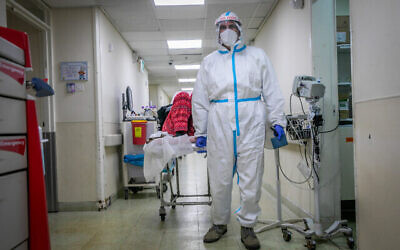 يرتدي موظفو المستشفى معدات السلامة أثناء عملهم في جناح فيروس كورونا في مركز كابلان الطبي في رحوفوت، 18 يناير، 2022 (Yossi Aloni / Flash90)