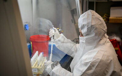 فنيون يجرون اختبارا تشخيصيا لكوفيد-19 في مختبر في فرع "لئوميت" للخدمات الصحية في أور يهودا، 21 يناير، 2022. (Yossi Zeliger / Flash90)