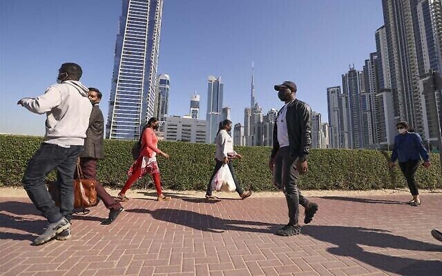 موظفون يسيرون الى أعمالهم في أول يوم جمعة عمل في دبي، 7 يناير، 2022. (Karim Sahib/AFP)