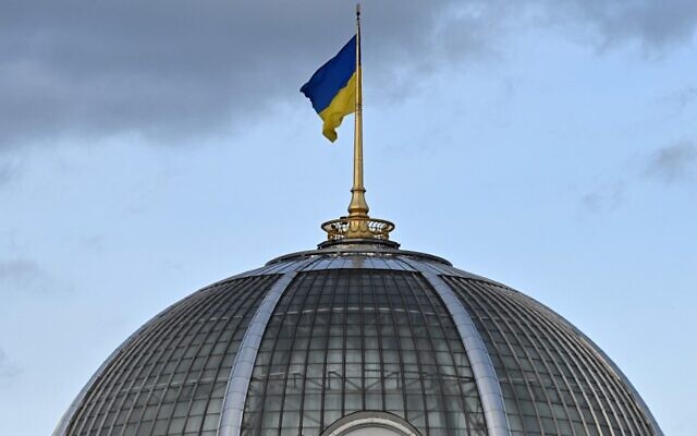 تُظهر هذه الصورة التي التقطت في 23 فبراير، 2022، العلم الأوكراني يرفرف فوق قبة البرلمان في كييف. (CREDITSERGEI SUPINSKY / AFP)