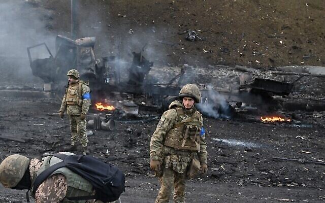 جنود أوكرانيون يبحثون عن قذائف غير منفجرة ويجمعونها بعد قتال مع القوات الروسية في العاصمة الأوكرانية كييف في صباح 26 فبراير، 2022. (Sergei Supinsky / AFP)