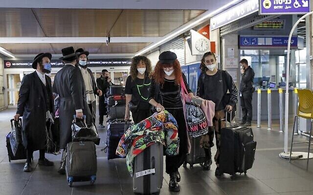 ركاب وصلوا حديثا من كييف يسيرون بأمتعتهم في مطار بن غوريون الإسرائيلي، 13 فبراير 2022 (Jack Guez / AFP)