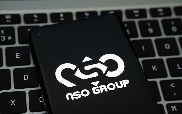 شعار NSO يظهر على هاتف ذكي موضوع على لوحة مفاتيح جهاز كمبيوتر محمول. (Mundissima / Alamy)