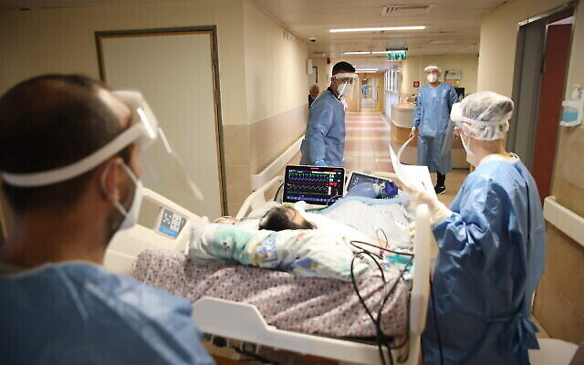 الطاقم الطبي في زيف يرتدي معدات واقية أثناء عمله في قسم كورونا بمستشفى في صفد، 1 فبراير، 2022. (David Cohen / Flash90)