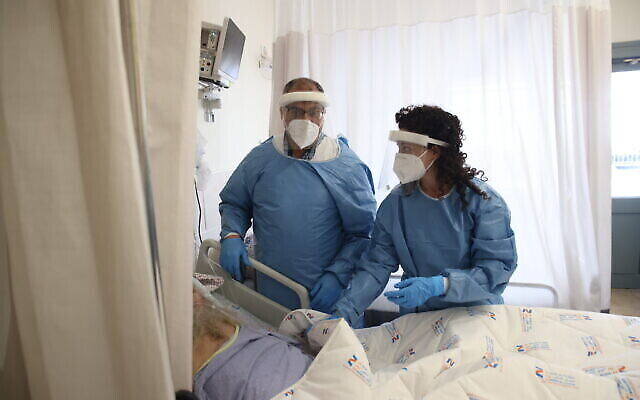الطاقم الطبي يرتدي معدات الوقاية أثناء عملهم في قسم كورونا في مستشفى زيف بمدينة صفد، 1 فبراير، 2022. (David Cohen / Flash90)