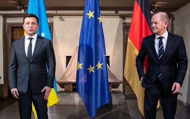المستشار الألماني أولاف شولتس (يمين) والرئيس الأوكراني فولوديمير زيلينسكي يقفان لالتقاط صورة أثناء لقائهما في مؤتمر ميونيخ للأمن في 19 فبراير 2022 (Sven Hoppe / POOL / AFP)