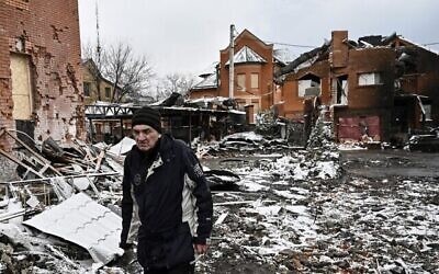 رجل يسير بين منازل دمرت خلال غارات جوية على مدينة بيلا تسيركفا بوسط أوكرانيا، 8 مارس، 2022. (Aris Messinis / AFP)