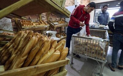 موظفون ليبيون يبيعون الخبز في مخبز بالعاصمة طرابلس، في 22 مارس 2022، مع ارتفاع أسعار الخبز والقمح بسبب الغزو الروسي لأوكرانيا (Mahmud Turkia / AFP)