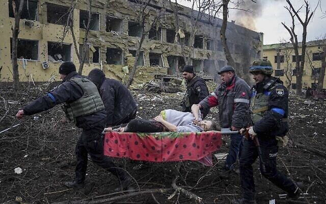موظفو الطوارئ والمتطوعون الأوكرانيون ينقلون امرأة حامل مصابة جراء قصف مستشفى الولادة في ماريوبول، أوكرانيا، 9 مارس، 2022. (AP Photo / Evgeniy Maloletka)