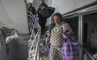 امرأة حامل تسير في الطابق السفلي في مستشفى الولادة الذي قصفته روسيا في ماريوبول، أوكرانيا،  9 مارس، 2022. (AP Photo / Evgeniy Maloletka)