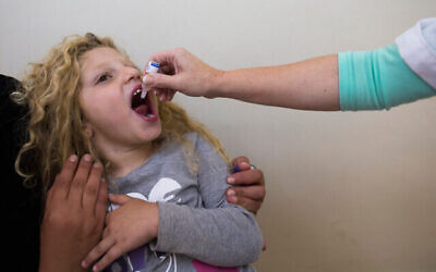 صورة توضيحية: طفلة تتلقى لقاح شلل الأطفال الفموي، 18 أغسطس 2013 (Yonatan Sindel / Flash90)