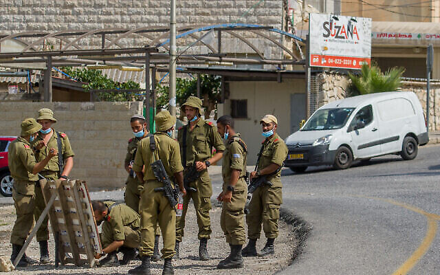 توضيحية: جنود إسرائيليون يرتدون كمامات عند مدخل قرية الجش ، شمال إسرائيل، 27 يوليو، 2020. (Flash90)
