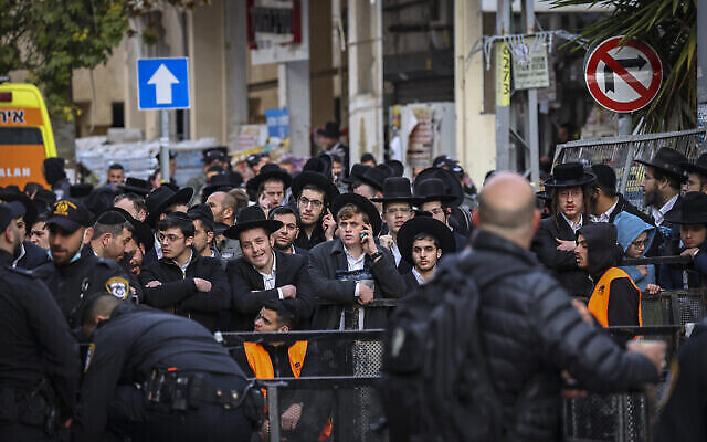 رجال يحتشدون خارج منزل الحاخام حاييم كانيفسكي في 20 مارس، 2022. (Yonatan Sindel / Flash90)