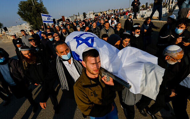 مشيعون يحملون جثمان مناحيم يحزقيل البالغ من العمر 67 عاما، والذي قُتل في إعتداء دام في اليوم السابق ، خلال جنازته في المقبرة في بئر السبع، جنوب إسرائيل، 23 مارس ، 2022. (Olivier Fitoussi/Flash90 )