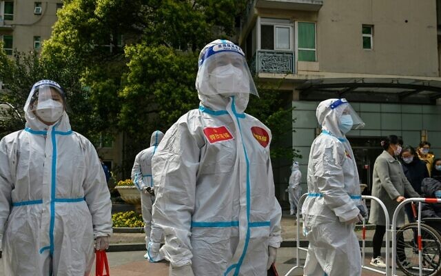 عمال ومتطوعو في مجمع حيث يتم إجراء اختبارات  للسكان لتشخيص فيروس كورونا  خلال المرحلة الثانية من عمليات الإغلاق لمنع انتشار كوفيد-19 في منطقة جينغان في شنغهاي، 1 أبريل، 2022.(  Hector RETAMAL / AFP)