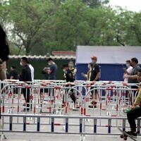 أشخاص يصطفون في طابور لاختبارات فيروس كورونا في محطة فحوصات على طول شارع في بكين في 25 أبريل، 2022. ( Noel Celis / AFP)