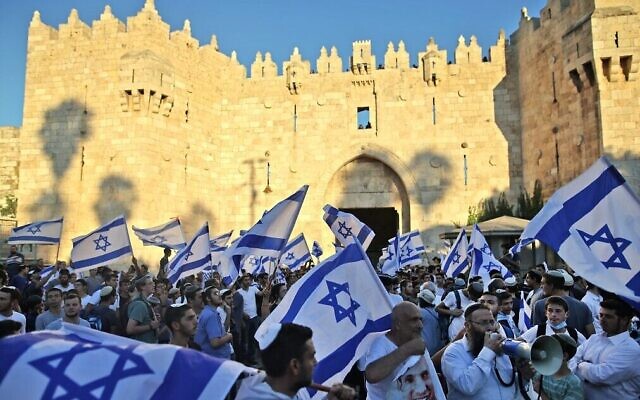 من الأرشيف: نشطاء يمين إسرائيليون يلوحون بالاعلام الاسرائيلية خلال مسيرة خارج باب العامود متوجهة الى البلدة القديمة في القدس، 15 يونيو، 2021. (Ahmad Gharabli / AFP)
milafi: yahud asarayiyl a