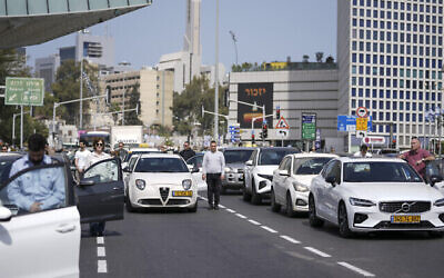 إسرائيليون يقفون بصمت بجانب سياراتهم على طريق سريع مع سماع صفارات الإنذار لمدة دقيقتين إحياء لذكرى ضحايا المحرقة النازية في تل أبيب، إسرائيل، 28 أبريل، 2022. (AP Photo / Ariel Schalit)