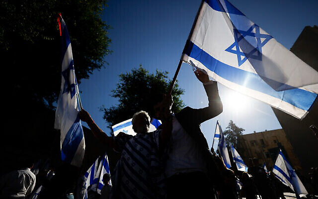 رجال يهود يرقصون مع الأعلام الإسرائيلية خلال مسيرة الأعلام بالقرب من البلدة القديمة في القدس، 15 يونيو، 2021. (Yonatan Sindel / Flash90)