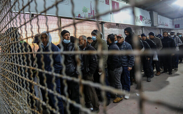عمال فلسطينيون يقفون في طابور في معبر إيرز، 13 مارس، 2022. (ِAttia Muhammed/Flash90)