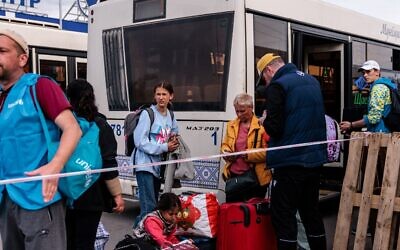 وصول أشخاص تم إجلاؤهم من مصنع آزوفستال في ماريوبول على متن حافلات إلى منطقة تسجيل ومعالجة للنازحين داخليًا في زابوريجيه، 3 مايو، 2022. (Dimitar DILKOFF / AFP)