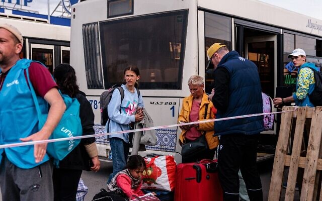 وصول أشخاص تم إجلاؤهم من مصنع آزوفستال في ماريوبول على متن حافلات إلى منطقة تسجيل ومعالجة للنازحين داخليًا في زابوريجيه، 3 مايو، 2022. (Dimitar DILKOFF / AFP)