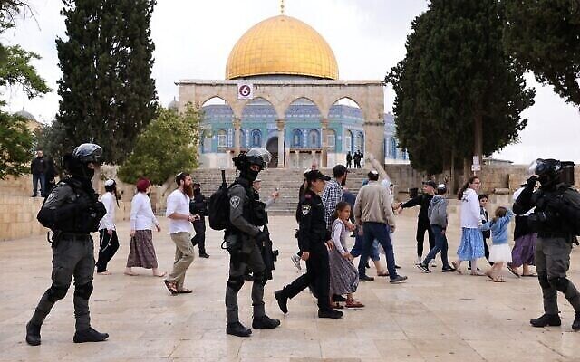 الشرطة الإسرائيلية ترافق مجموعة من اليهود تقوم بجولة في الحرم القدسي في 5 مايو 2022، حيث أعيد فتح الموقع المقدس في القدس للزوار غير المسلمين.  (Ahmad Gharabli/AFP)
