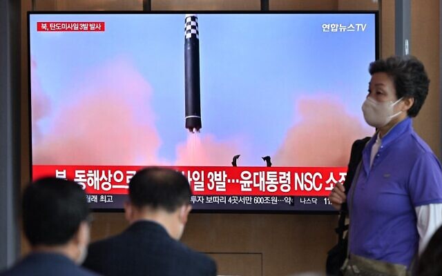 أشخاصا ي شاشة تلفزيونية تُظهر بثًا إخباريًا مع لقطات  أرشيفية لتجربة صاروخية  أجرتها كوريا الشمالة، في محطة للسكك الحديدية في سيول في 25 مايو 2022، بعد أن أطلقت كوريا الشمالية ثلاثة صواريخ باليستية باتجاه بحر اليابان وفقًا لجيش كوريا الجنوبية. (  JUNG YEON-JE / AFP)