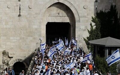 مشاركون يهود في "مسيرة الأعلام" عبر باب العامود إلى البلدة القديمة في القدس في 29 مايو 2022، حيث تحتفل إسرائيل ب"يوم أورشليم".  (Ahmad Gharabli/AFP)