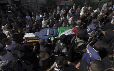 مسلحون فلسطينيون يحملون جثمان شيرين أبو عاقلة، مراسلة قناة الجزيرة، إلى المشرحة داخل المستشفى في بلدة جنين بالضفة الغربية، 11 مايو، 2022. (AP Photo / Majdi Mohammed)