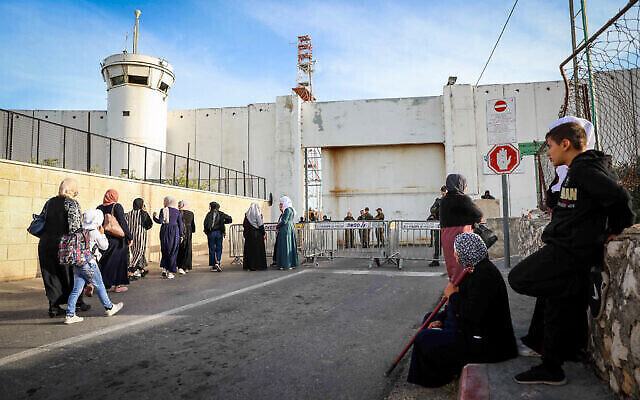 دخول فلسطينيين عبر نقطة تفتيش إسرائيلية بالقرب من مدينة بيت لحم بالضفة الغربية، 22 أبريل، 2022. (Wisam Hashlamoun / Flash90)