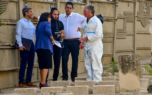 أعضاء فريق الطب الشرعي الإسرائيلي يفتحون قبر عوزيئيل حوري لأخذ عينة من الحمض النووي في مقبرة سيغولا في بتاح تكفا، 23 مايو 2022 (Avshalom Sassoni / Pool via Flash90)
