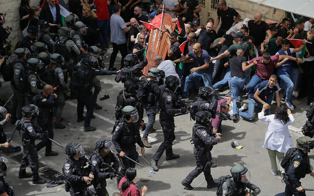 الشرطة الإسرائيلية تواجه المشيعين الذين حملوا نعش مراسلة الجزيرة شيرين أبو عاقلة، الذي كاد أن يسقط، خلال جنازتها في القدس، 13 مايو، 2022. (AP Photo / Maya Levin)