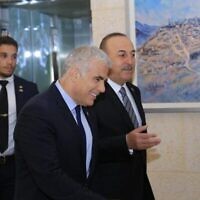 وزير الخارجية يائير لابيد (وسط) يتحدث مع نظيره التركي مولود تشاووش أوغلو في وزارة الخارجية في القدس، 25 مايو، 2022. (Asi Efrati / GPO)