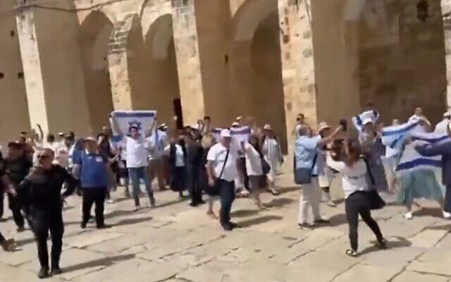 قوميون متدينون يهود يلوحون بالعلم الإسرائيلي في الحرم القدسي، 29 مايو، 2022. (Screen grab)