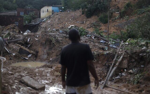 رجل ينظر إلى موقع انهيار تربة في جارديم مونتيس فيرديس، حي إيبورا، في ريسيفي، بولاية بيرنامبوكو، البرازيل ، في 31 مايو 2022.  ( SERGIO MARANHAO / AFP)