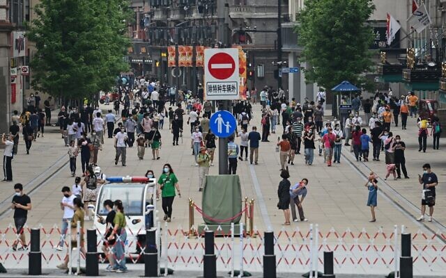 المشاة يسيرون في منطقة هوانغبو في شنغهاي في 1 يونيو 2022، بعد تخفيف قيود كوفيد-19 في المدينة بعد إغلاق دام شهرين. (Hector RETAMAL / AFP)
