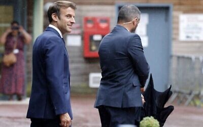 الرئيس الفرنسي إيمانويل ماكرون (إلى اليسار)  خلال مغادرته بعد الإدلاء بصوته في المرحلة الثانية من الانتخابات البرلمانية الفرنسية في مركز اقتراع في لو توكي، شمال فرنسا، 19 يونيو، 2022. (Ludovic MARIN / AFP)