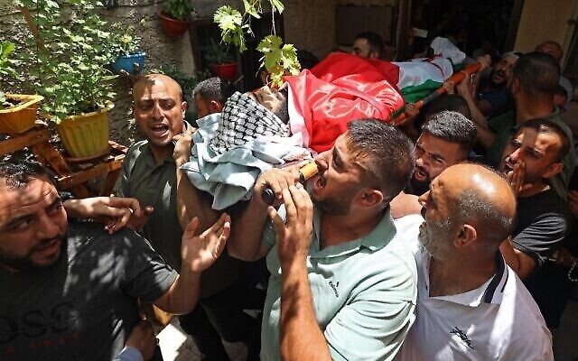 مشيعون يحملون جثمان علي حرب، الذي تعرض للطعن على يد مستوطن إسرائيلي كما يُزعم، خلال جنازته في قرية اسكاكا شمال الضفة الغربية، 22 يونيو، 2022. (JAAFAR ASHTIYEH / AFP)