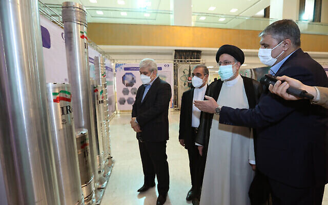 الرئيس الإيراني إبراهيم رئيسي، الثاني من اليمين ، يستمع إلى شرح أثناء مشاهدة جهاز طرد مركزي متقدم في معرض لإنجازات إيران النووية في طهران، إيران في 9 أبريل، 2022.  (Iran President’s Office)