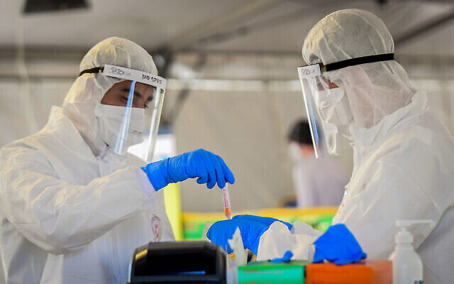 أعضاء الفريق الطبي لنجمة داوود الحمراء في موقع لاختبارات فيروس كورونا في تل أبيب، 22 مارس، 2020 (Flash90)