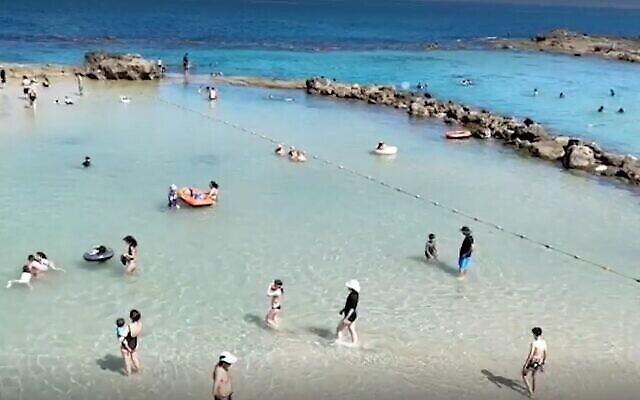 الإسرائيليون يستمتعون بالشاطئ، 4 يونيو، 2022 (Screen Grab / Israel National Parks Authority)