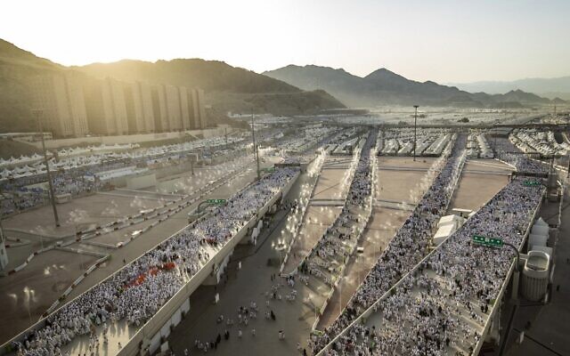 آلاف الحجاج يسيرون الى عبر وادي منى ، بالقرب من مكة في غرب المملكة العربية السعودية، لرمي جمرة العقبة الكبرى، في بداية عيد الأضحى، 9 يوليو 2022 (DELIL SOULEIMAN / AFP)