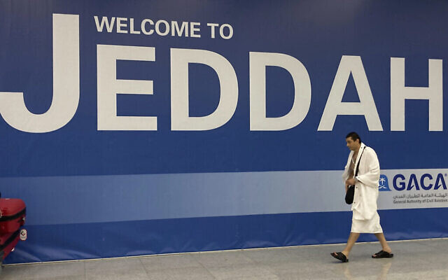 حاج مسلم يمشي أمام لافتة ترحيب عند وصوله إلى مطار الملك عبد العزيز الدولي في جدة، المملكة العربية السعودية، الجمعة 1 يوليو 2022 (AP Photo / Amr Nabil)