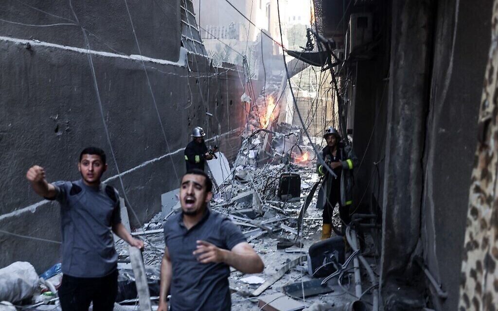 قوات الإنقاذ والإطفاء يخمدون حريقًا وسط الدمار في أعقاب غارة جوية إسرائيلية على مدينة غزة ، 5 أغسطس 2022 (Mohammed ABED / AFP)