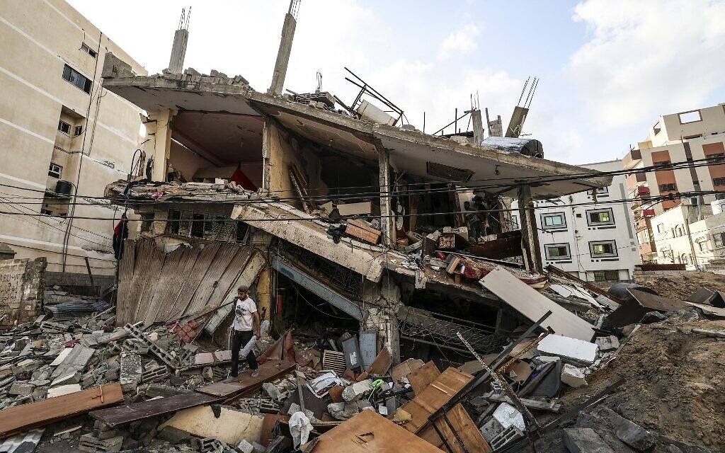 فلسطينيون بين أنقاض منزلهم، في أعقاب الغارات الجوية الإسرائيلية على مدينة غزة، 7 أغسطس ، 2022 (Mahmud Hams/AFP)