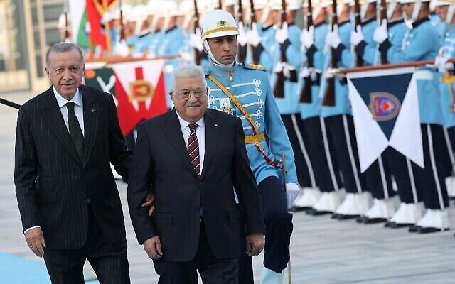 الرئيس التركي رجب طيب إردوغان (على يسار الصورة) يسير مع رئيس السلطة الفلسطينية محمود عباس (وسط الصورة) خلال حفل استقبال رسمي في المجمع الرئاسي في أنقرة، 23 أغسطس، 2022. (Adem Altan / AFP)