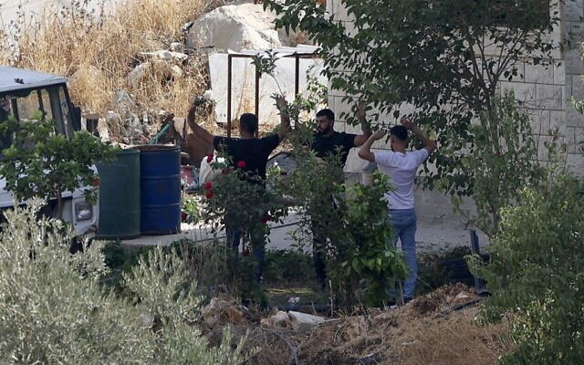 نبيل الصوالحي ونهاد عويص (يمين) يستسلمان للقوات الإسرائيلية بعد معركة بالأسلحة النارية في بلدة روجيب شمال الضفة الغربية، بالقرب من نابلس، 30 أغسطس 2022 (JAAFAR ASHTIYEH / AFP)