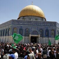 أشخاص يرفعون أعلام حركة حماس في الحرم القدسي بالبلدة القديمة، 7 مايو 2021 (Jamal Awad / Flash90)